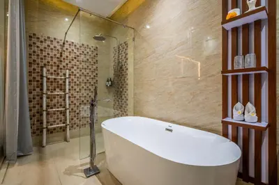 a bathroom with a tub and a glass shower at Villa Amelie by JB Villas in Seminyak