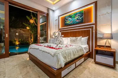 a bedroom with a bed with a stuffed animal on it at Villa Amelie by JB Villas in Seminyak