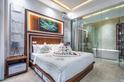 a bedroom with a large bed and a bath tub at Villa Amelie by JB Villas in Seminyak