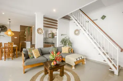 a living room with a couch and a staircase at Villa Miamara by Bali Villa Solutions in Seminyak