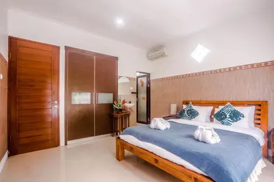 a bedroom with a large bed with two pillows on it at Villa Miamara by Bali Villa Solutions in Seminyak