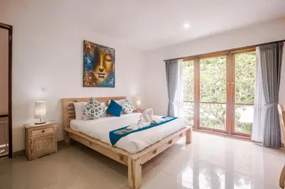 a bedroom with a bed and a large window at Villa Miamara by Bali Villa Solutions in Seminyak