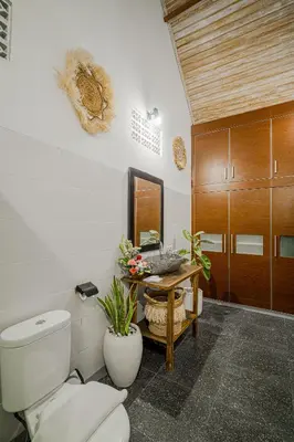 a bathroom with a toilet and a table with a mirror at Villa Miamara by Bali Villa Solutions in Seminyak