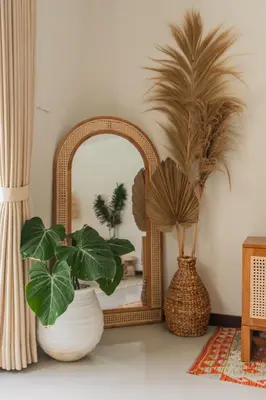 a mirror and two potted plants in front at Villa Nana by Pertama Management in Seminyak