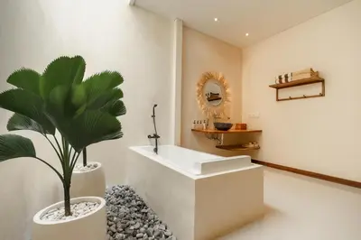 a bathroom with a white tub and a plant at Villa Nana by Pertama Management in Seminyak