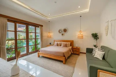 a bedroom with a bed and a green couch at Villa Nana by Pertama Management in Seminyak