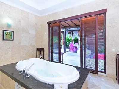 a bathroom with a large tub in a room at Romantic Private Villas Kuta Bali in Kuta