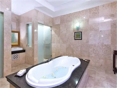 a large bathroom with a tub and a sink at Romantic Private Villas Kuta Bali in Kuta