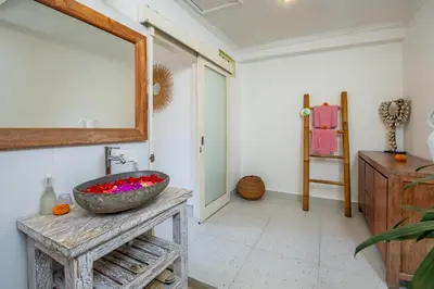 a bathroom with a sink and a mirror on a table at Villa Anouk in Seminyak