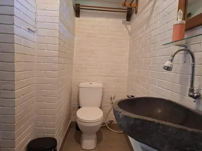 a bathroom with a toilet and a sink and a tub at Oma Joglo Jimbaran in Jimbaran