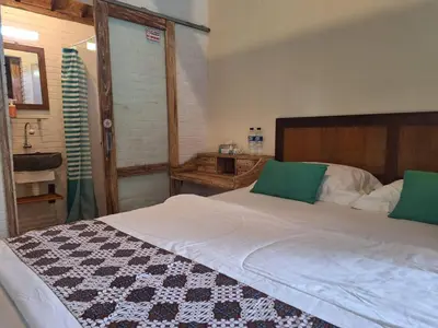 a bedroom with a large white bed with green pillows at Oma Joglo Jimbaran in Jimbaran