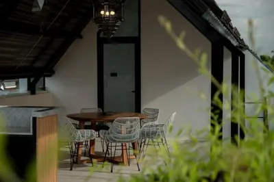 a wooden table and chairs on a patio at Villa Talisman - Luxury Rooftop Canggu Villa Only 5 mins to Beach in Canggu