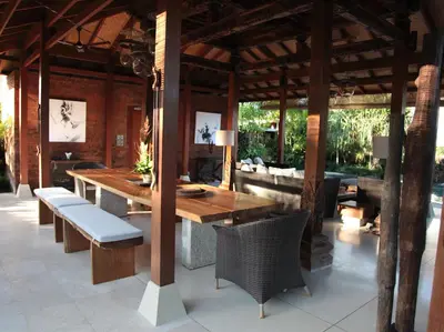an outdoor dining room with a wooden table and chairs at Dea Villas in Canggu