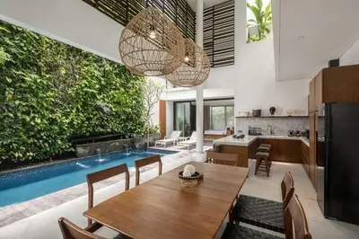 a kitchen and living room with a table and a pool at Villa Talisman - Stylish Canggu with Rooftop Villa 5 mins to Beach in Canggu
