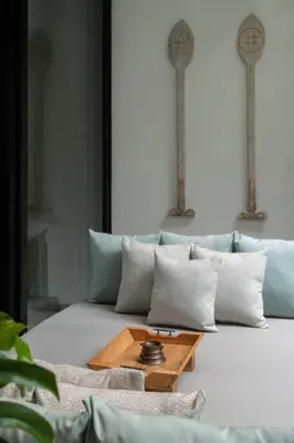 a couch with pillows and a wooden table on it at Villa Talisman - Stylish Canggu with Rooftop Villa 5 mins to Beach in Canggu