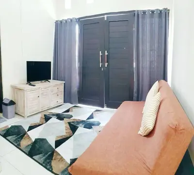 a living room with a couch and a dresser at Laura Dewi House in Jimbaran