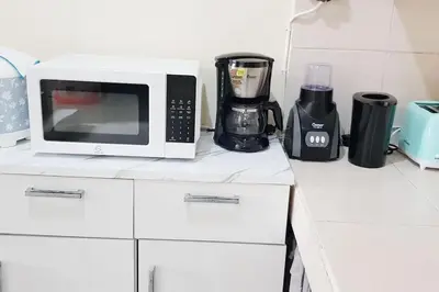 a white microwave sitting on top of a counter at Laura Dewi House in Jimbaran