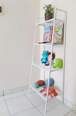 a white shelf with toys and books on it at Laura Dewi House in Jimbaran