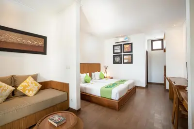a hotel room with a bed and a couch at Sedasa Lodge in Canggu
