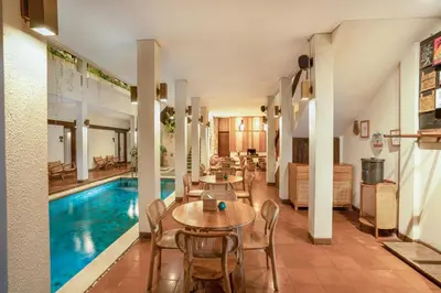 a pool with tables and chairs next to a swimming pool at Sedasa Lodge in Canggu