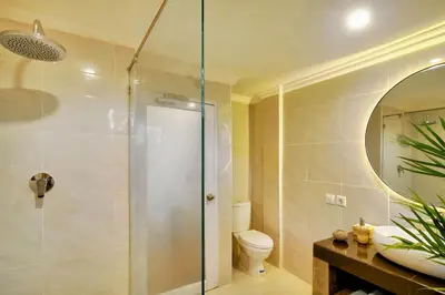 a bathroom with a shower and a toilet and a sink at Selasih Beach House in Seminyak