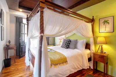 a bedroom with a canopy bed with white curtains at Selasih Beach House in Seminyak