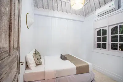 a white room with a bed and a window at Villa Dolcevita Seminyak in Seminyak