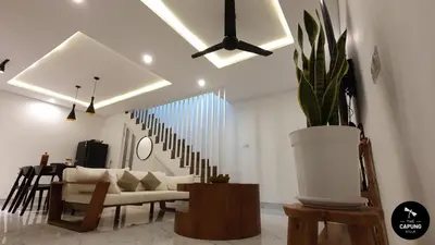 a living room with a couch and a potted plant at Capung Smart Residence in Sanur