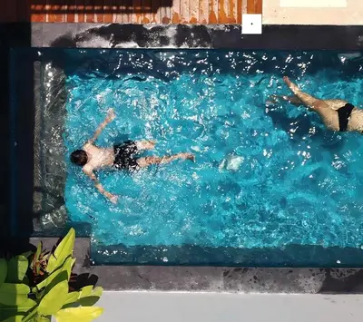 a group of people swimming in a swimming pool at Capung Smart Residence in Sanur