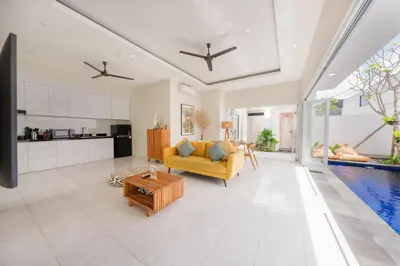 a living room with a yellow couch and a pool at The Eclipse Villas - The Luxurious 2BR Private Pool Canggu Getaway in Canggu