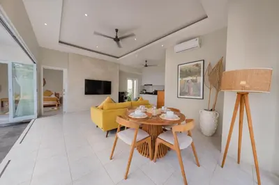 a living room with a table and a yellow couch at The Eclipse Villas - The Luxurious 2BR Private Pool Canggu Getaway in Canggu
