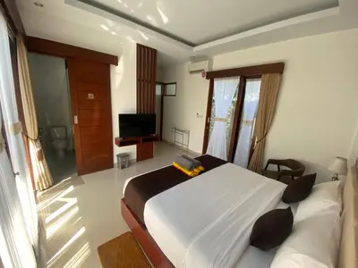 a bedroom with a large bed and a television at SONGOKU HOUSE APARTMEN in Pesanggaran