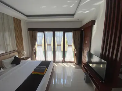 a bedroom with a large bed and a large window at SONGOKU HOUSE APARTMEN in Pesanggaran