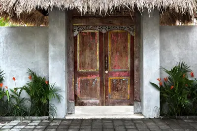 an entrance to a house with a wooden door at Surflodge Limasan Bali in Kerobokan
