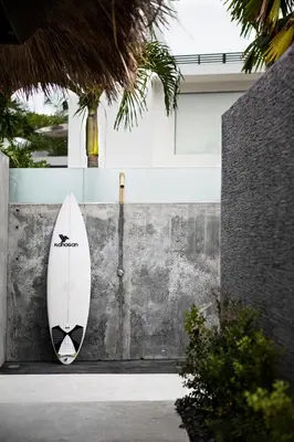 a surfboard is leaning against a wall at Surflodge Limasan Bali in Kerobokan