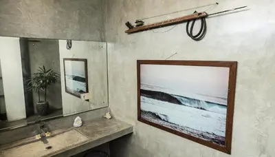 a bathroom with a picture of the ocean on the wall at Surflodge Limasan Bali in Kerobokan