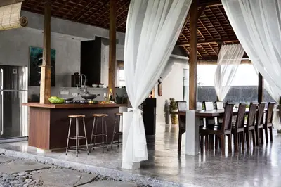 a kitchen with a table and chairs in a room at Surflodge Limasan Bali in Kerobokan