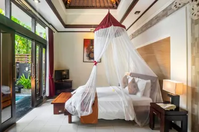 a bedroom with a bed with a mosquito net at Swaran 1 BR Private Pool Villa in Seminyak