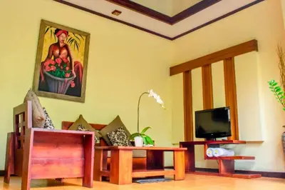 a living room with a table and a tv at Swaran 1 BR Private Pool Villa in Seminyak