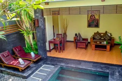 a living room with chairs and a pool at Swaran 1 BR Private Pool Villa in Seminyak