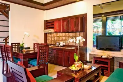 a living room with a table and a kitchen at Catra 3 BR Private Pool Villa in Seminyak