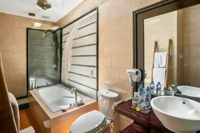 a bathroom with a tub and a sink and a toilet at Catra 3 BR Private Pool Villa in Seminyak