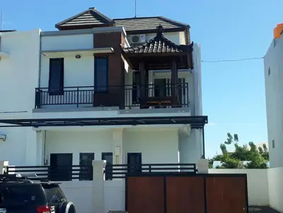 a white house with a balcony on top of it at Chandra's house in Pesanggaran