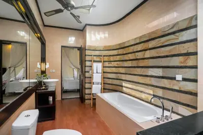a bathroom with a large tub and a sink at Kastara 4 BR Private Pool Villa in Seminyak