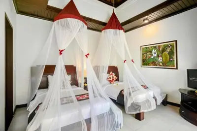 a bedroom with two beds with mosquito nets at Kastara 4 BR Private Pool Villa in Seminyak