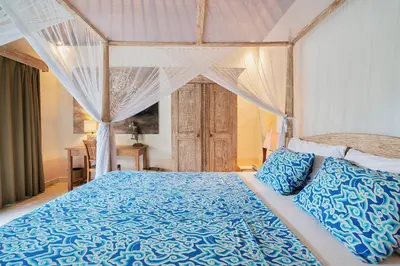 a bedroom with a blue bed with a canopy at Villa Anais Seminyak in Seminyak