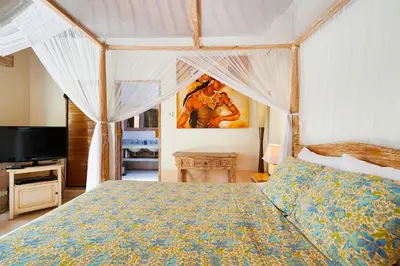 a bedroom with a bed and a television in it at Villa Anais Seminyak in Seminyak