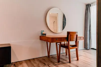 a dressing table with a mirror and a chair at Sunrise Suite Seminyak by ARM Hospitality in Kerobokan