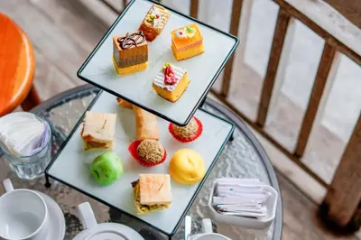a plate of desserts on a glass table at Sunrise Suite Seminyak by ARM Hospitality in Kerobokan