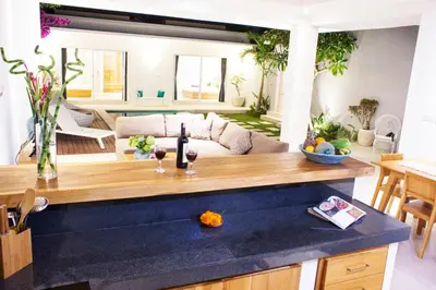 a living room with a couch and a table with wine glasses at Villa Angela in Seminyak